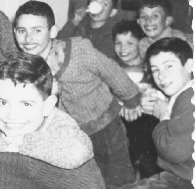 Fotografía antigua en blanco y negro de niños sonrientes en una chocolatada en Bagà, entre ellos el padre de Roser Amills