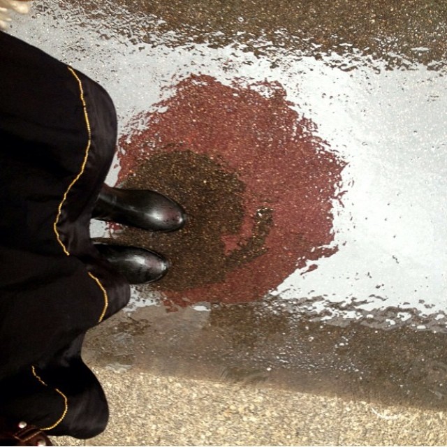 Zapatos negros sobre el asfalto mojado de una calle de Barcelona