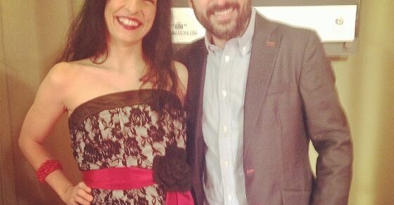Roser Amills con vestido de encaje negro y Jordi Évole ante un cartel de los premios Ondas