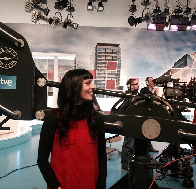Roser Amills con vestido rojo en el plató de Vespre a La 2, junto a una cámara de TVE