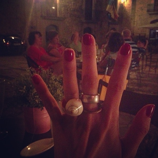 Mano con las uñas rojas y un anillo nuevo de caracola