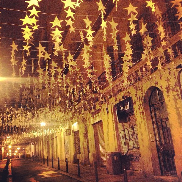 Calle de Gràcia de noche decorada con estrellas doradas por las fiestas