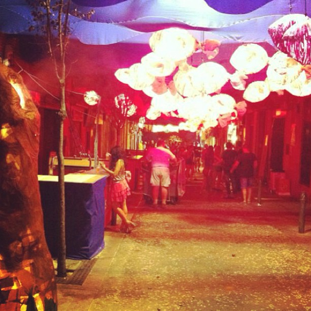 Calle decorada con farolillos rojos y rosas durante la fiesta mayor de Gràcia