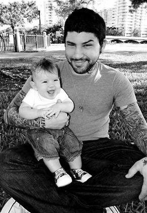 Darren Brass, tatuador, con su bebé en brazos