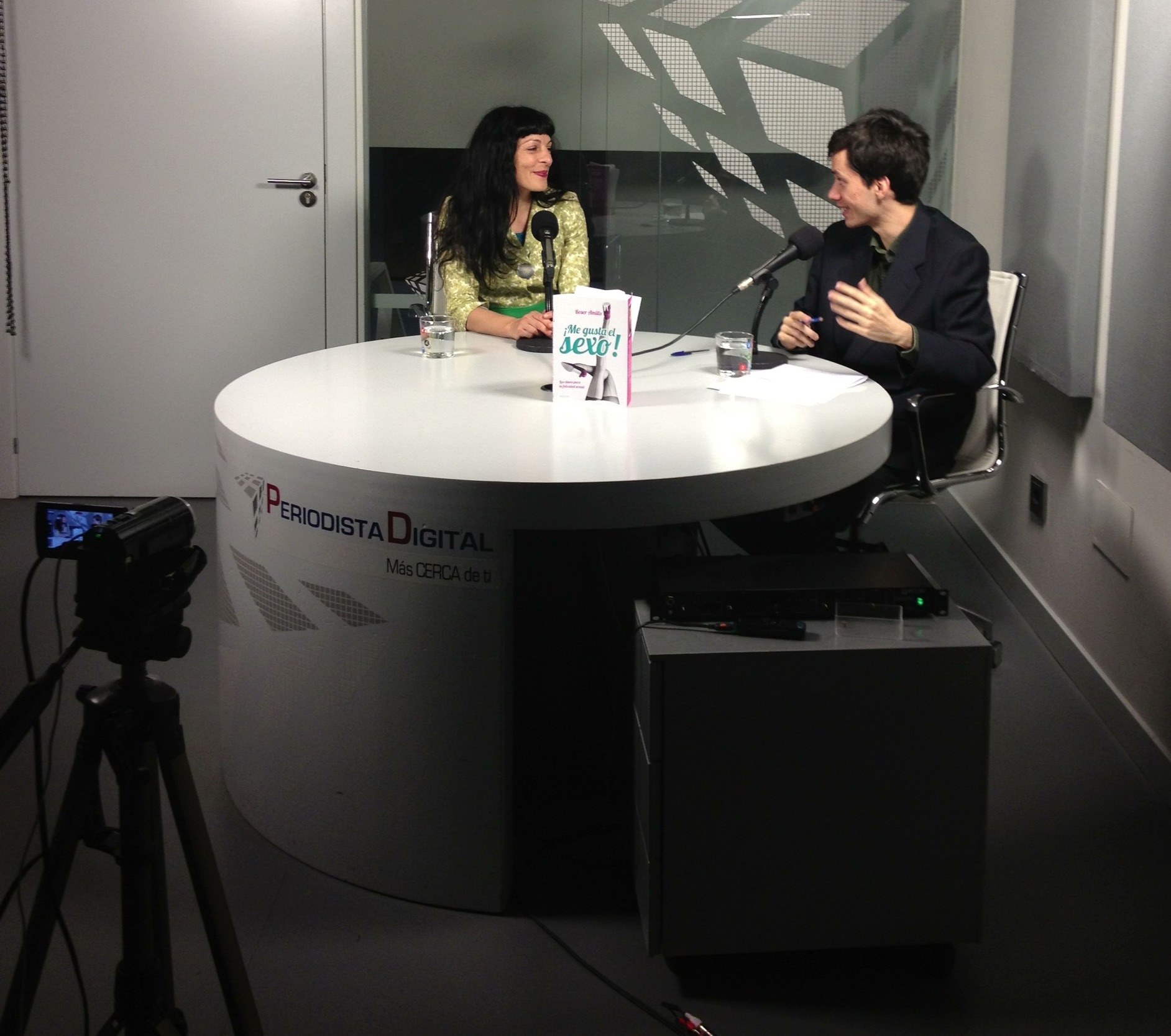 Roser Amills conversa con el entrevistador en el plató de Periodista Digital, con un ejemplar de ¡Me gusta el sexo! sobre la mesa, el 7 de junio de 2013