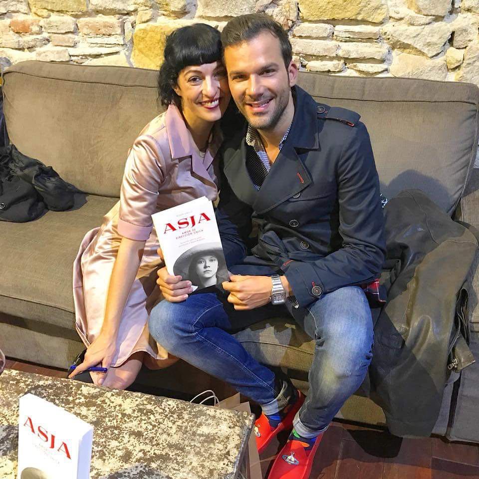 Roser Amills, con un ejemplar de Asja, sentada en un sofá junto a Fabio Vieira, que lleva zapatillas rojas, en la Nau Comanegra