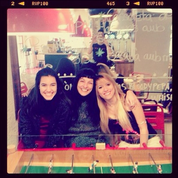 Tres dones somrients abraçades després d’un futbolí en un bar: Roser Amills amb Anna Se Mu i Marta Moya Abad-Torres