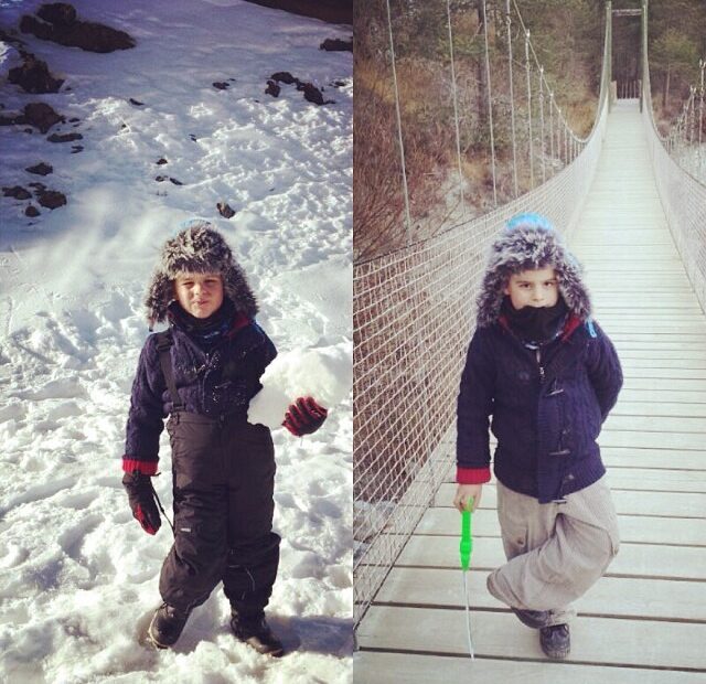Joan, de sis anys, a la neu i sobre un pont penjant, amb abric i barret de pelfa