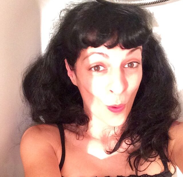 Selfi de Roser Amills con el pelo suelto y los labios en gesto de beso, junto a un cuarto de baño