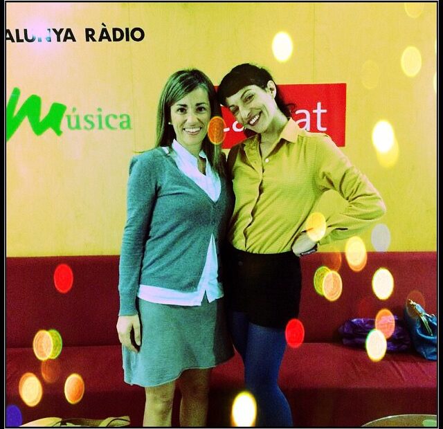 Dues dones somriuen davant d'un fons groc i vermell amb el logotip de Catalunya Ràdio