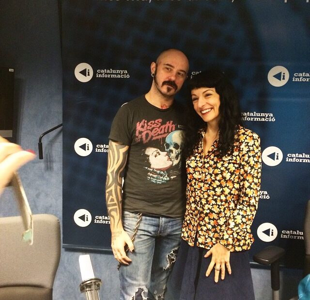 Dues persones posen davant d'un fons de Catalunya Informació