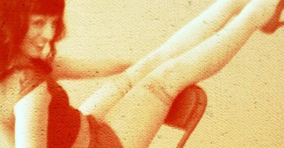 Roser Amills sentada en una silla plegable con las piernas levantadas, en una fotografía de tonos rojizos y aire retro