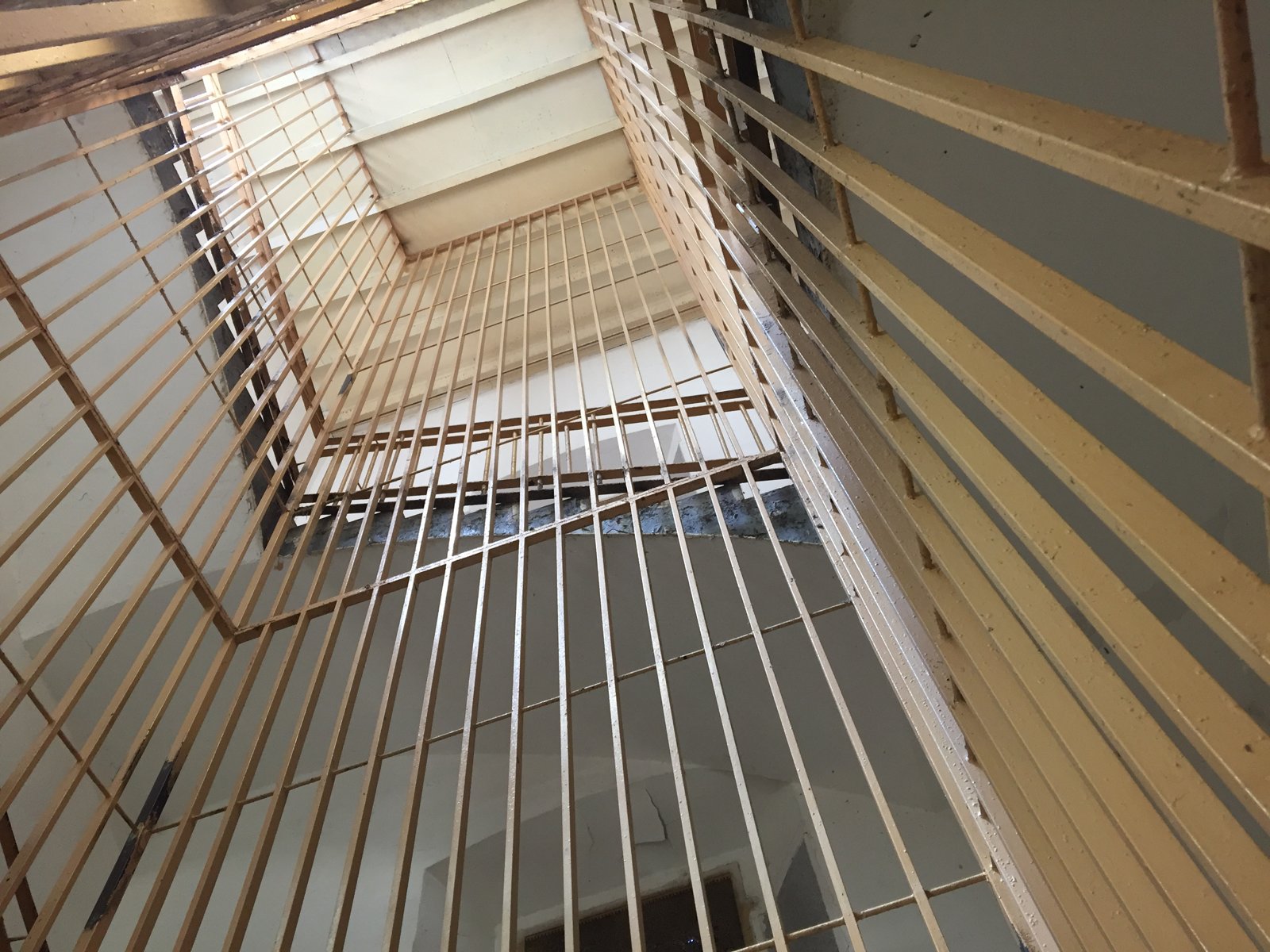 Hueco de escalera de La Model visto desde abajo, con barandillas enrejadas y un lucernario