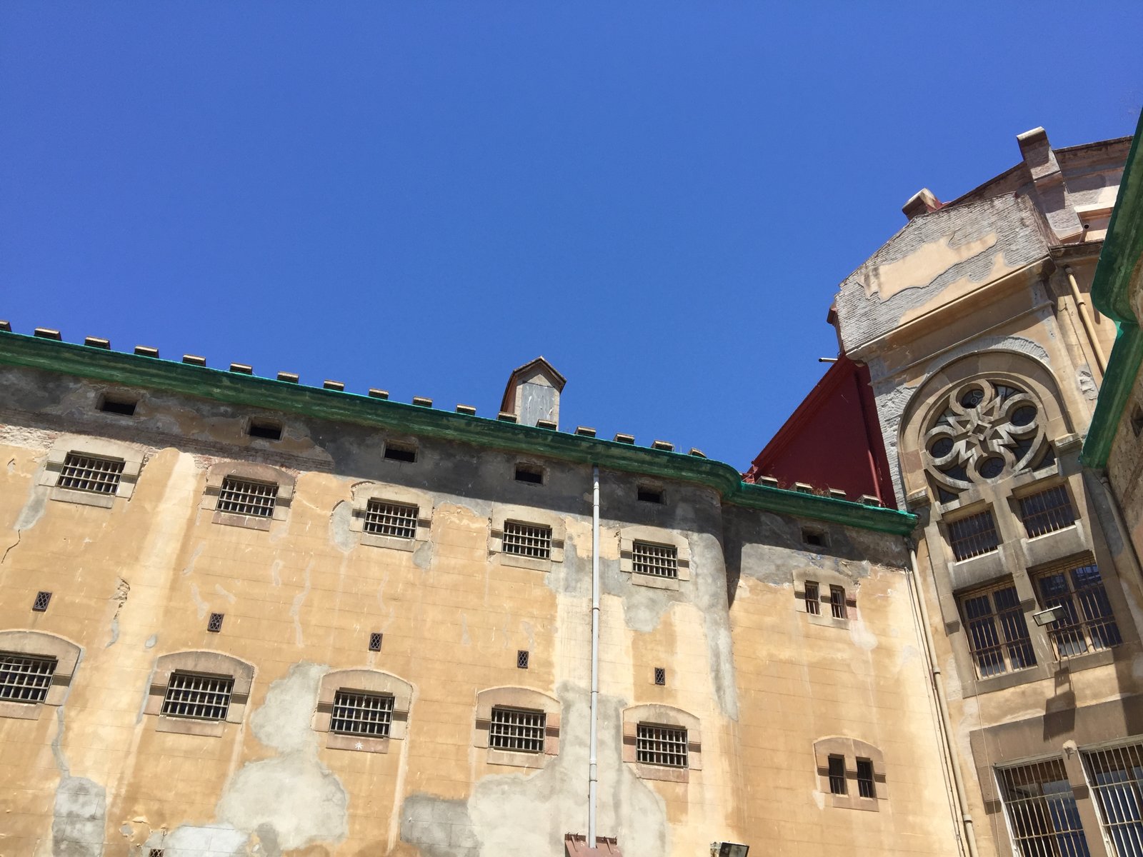Fachada exterior de La Model con hileras de ventanas enrejadas bajo un cielo azul