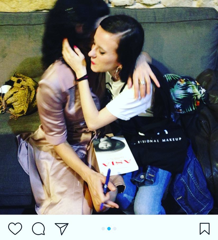 Roser Amills abraza a Laia Prat en un sofá, con un ejemplar de Asja sobre las rodillas