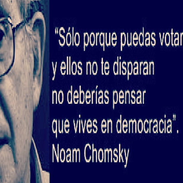 Cita de Noam Chomsky sobre votar y vivir en democracia, junto a un retrato del autor