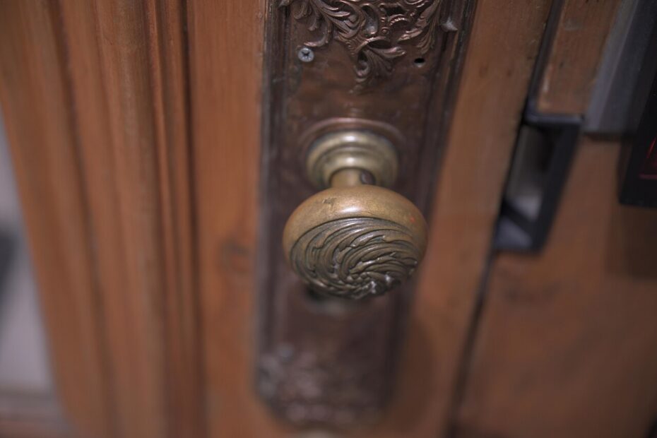 Picaporte antiguo de latón en una puerta de madera
