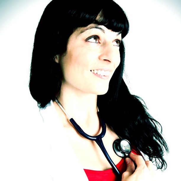 Retrato de una mujer sonriente con bata blanca y un fonendoscopio