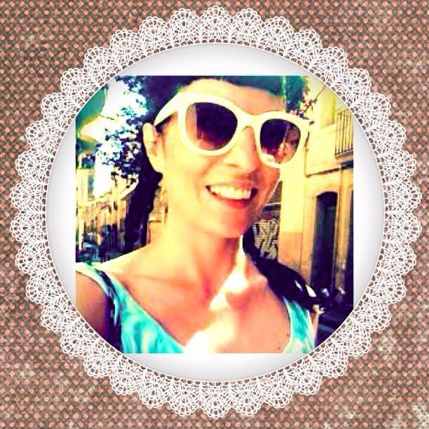Roser Amills sonriente con gafas de sol blancas, en un marco de encaje