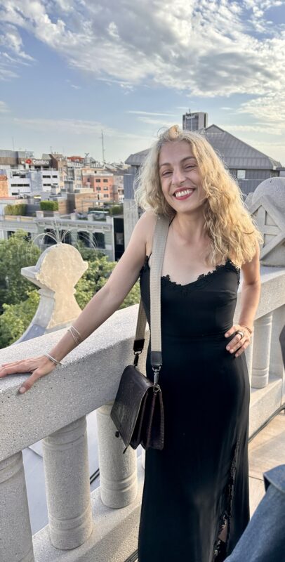 Roser Amills, con vestido negro, apoyada en la barandilla de un balcón.