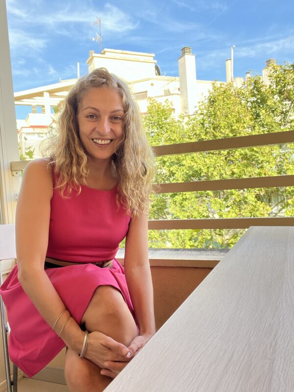 Roser Amills, con vestido rosa, sentada en una terraza de Palma.