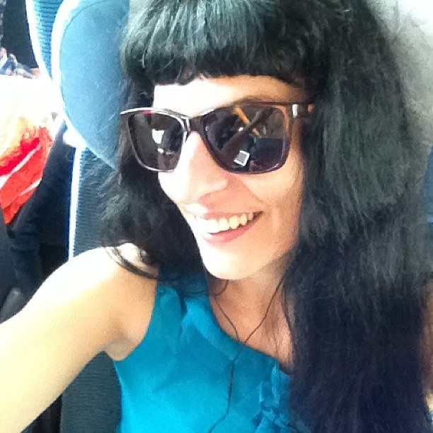 Roser Amills sonríe con gafas de sol en su asiento del tren, camino de la Feria del Libro de Madrid, el 7 de junio de 2013