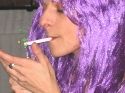 Roser Amills, con peluca lila, enciende un cigarrillo