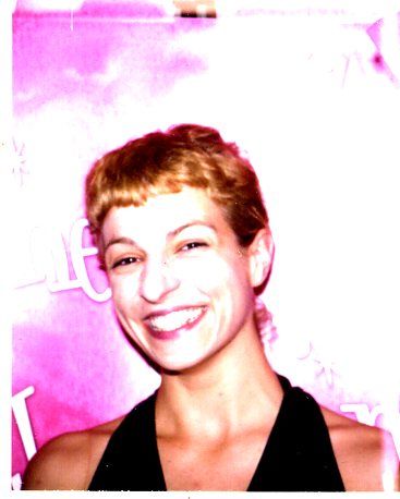 Roser Amills, sonriente y con el pelo corto, ante un fondo rosa