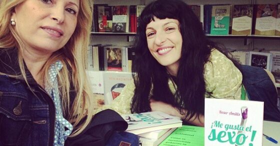 Roser Amills en la caseta de firmas de la Feria del Libro de Madrid junto a una lectora, con ejemplares de ¡Me gusta el sexo! sobre el mostrador, el 7 de junio de 2013