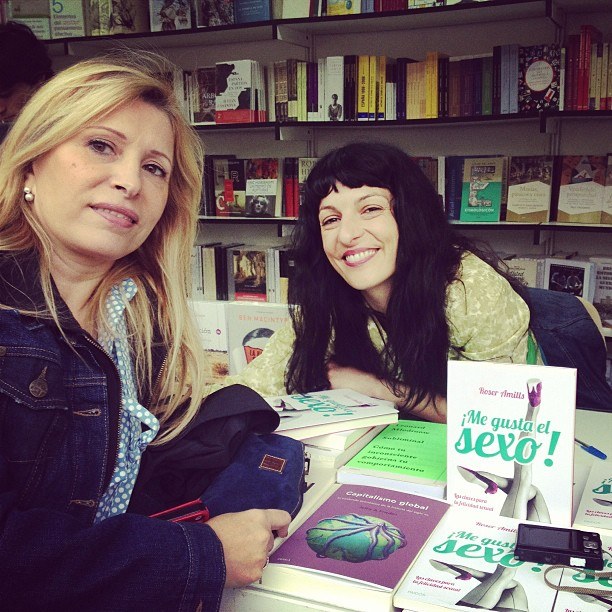Roser Amills en la caseta de firmas de la Feria del Libro de Madrid junto a una lectora, con ejemplares de ¡Me gusta el sexo! sobre el mostrador, el 7 de junio de 2013
