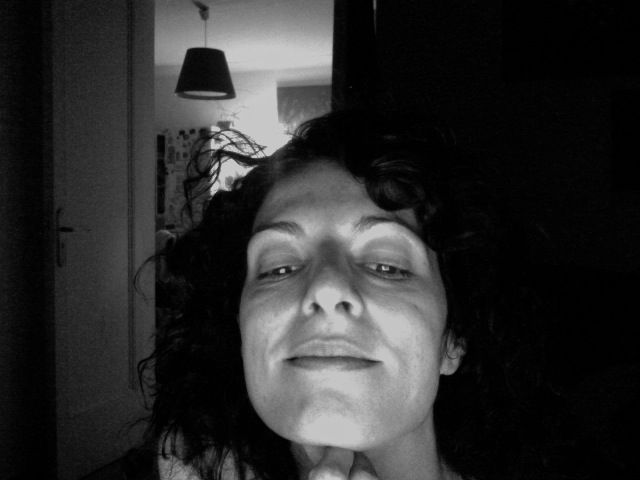 Roser Amills, en blanco y negro, con el pelo rizado y una media sonrisa