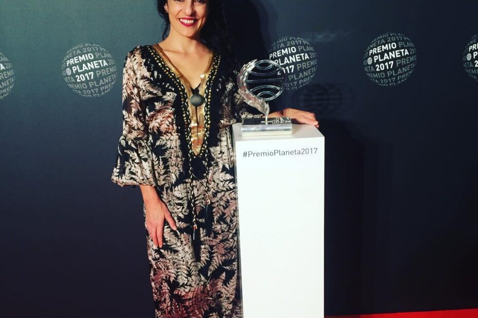 Roser Amills, con vestido largo estampado de Otto van Rhusk BCN, posa junto al trofeo del Premio Planeta 2017 ante el fondo de la gala