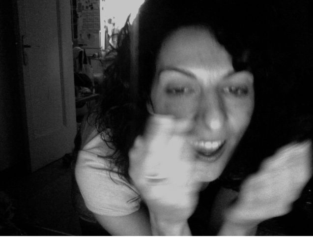 Retrato en blanco y negro de Roser Amills riendo y tapándose con la mano