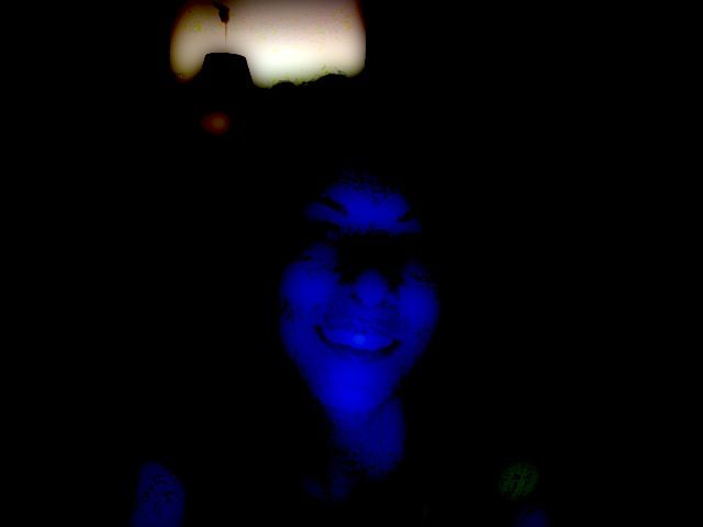 Rostro sonriente de Roser Amills iluminado con luz azul en la oscuridad