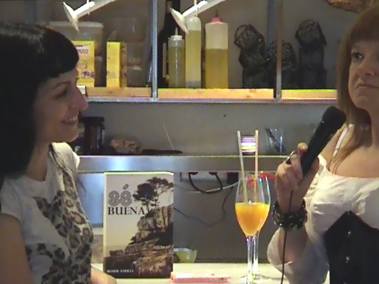 Roser Amills y Laura Carrión, con micrófono, junto a un ejemplar de Sé buena en el Pepa Tomate