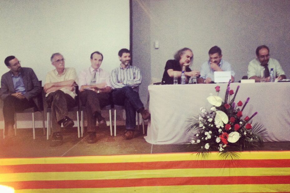 Mesa redonda de la Jornada d’estudis càtars de Bagà, con los ponentes sentados ante una mesa con flores y una senyera, el 5 de octubre de 2013