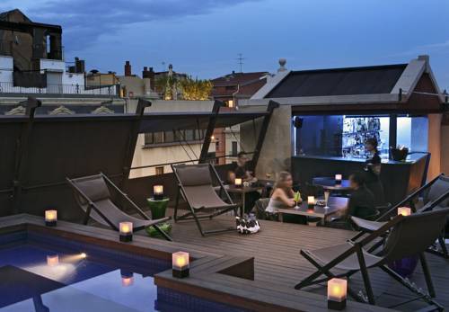 Terrat d’hotel amb piscina i gandules al capvespre