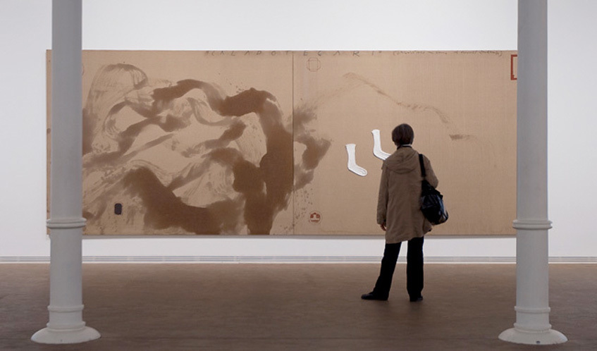 Una visitant contempla una gran pintura en una sala d’exposicions